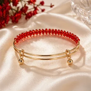 Red crystal bracelet Pakistan with elegant gold-tone cuff design