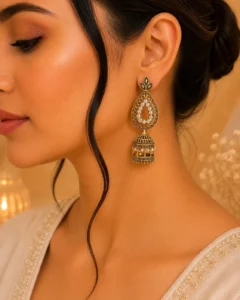 Woman wearing antique gold jhumka earrings with teardrop and dome design