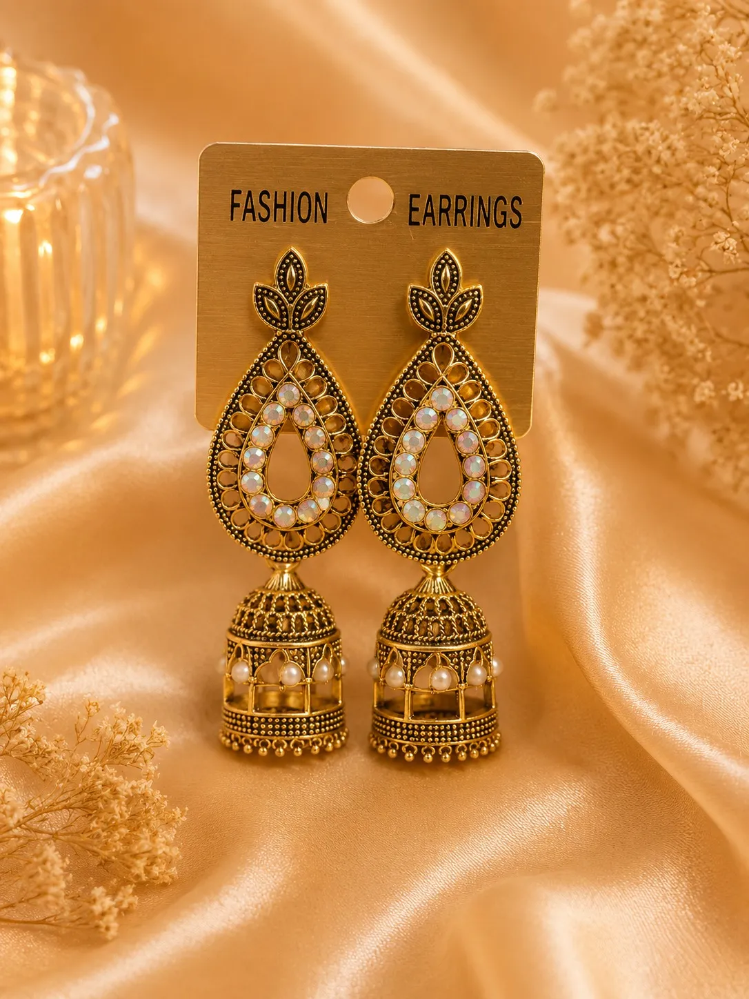 WhatsApp Image 2026-05-22 at 4.15.14 PM (2) Antique gold-tone jhumka earrings with pearl-style detailing displayed on satin background
