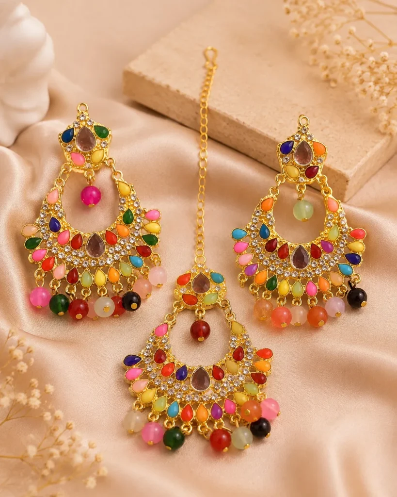 Gold-tone multicolor chandbali earrings with hanging bead detailing displayed on satin background