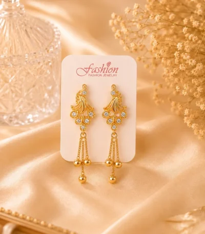 Gold-tone crystal tassel earrings displayed on jewelry card