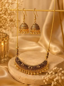 Antique gold necklace with matching jhumka earrings on display
