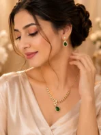 Woman wearing emerald green teardrop necklace with matching earrings