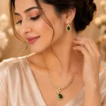 Woman wearing emerald green teardrop necklace with matching earrings