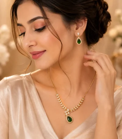 Woman wearing emerald green teardrop necklace with matching earrings