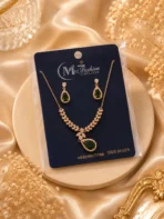Gold plated green crystal necklace set displayed on luxury jewelry card