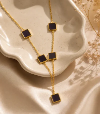 Black square lariat necklace gold with 5 enamel station tiles on cable chain worn by woman