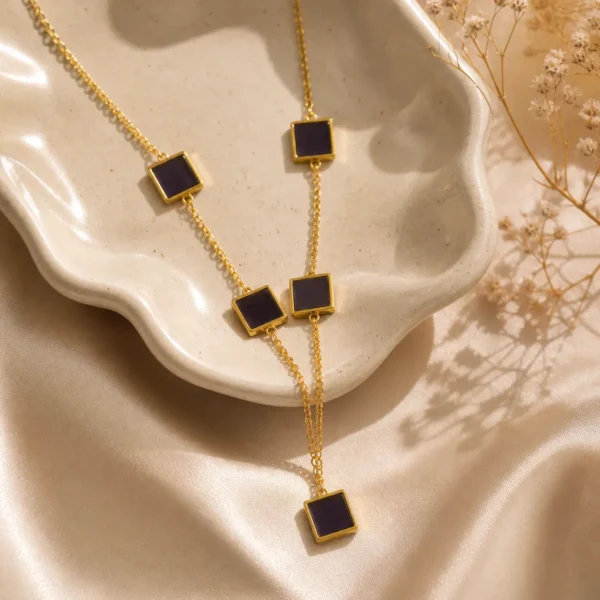 Black square lariat necklace gold with 5 enamel station tiles on cable chain worn by woman