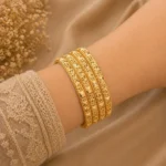 Diamond cut gold bangles Pakistan with floral engraving and 4-piece stack
