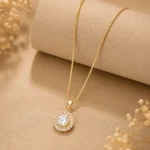 Gold halo pendant necklace with CZ baguette stones on box chain worn by woman