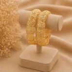 Traditional gold plated bangles Pakistan with intricate floral filigree cutwork on display