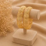 Traditional gold plated bangles Pakistan with intricate floral filigree cutwork on display