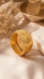 Wide gold bangle pair Pakistan — cross-engraved lattice kangan set worn on wrist by LumiraPK
